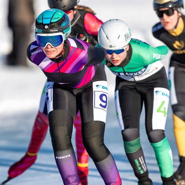 Daniëlle Bekkering op natuurijs als gepensioneerde schaatsster met rugnummer 9 Daniëlle Bekkering schaatst op natuurijs in een paars-roze schaatspak met nummer 9, voorop in het peloton tijdens een wedstrijd na haar officiële afscheid.