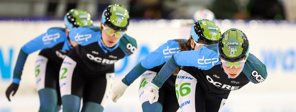 Marathonschaatsteam Daniëlle Bekkering met DCP en OCRE sponsorlogo’s Schaatsers van het marathonschaatsteam onder leiding van Daniëlle Bekkering in actie, gekleed in zwart-blauwe pakken met DCP en OCRE sponsoring.